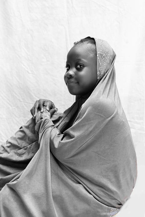 Grayscale Photo of a Girl in a Hijab Looking at the Camera