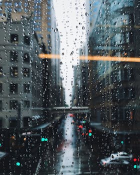 Moody view through a rain-streaked window of a bustling Sydney street.