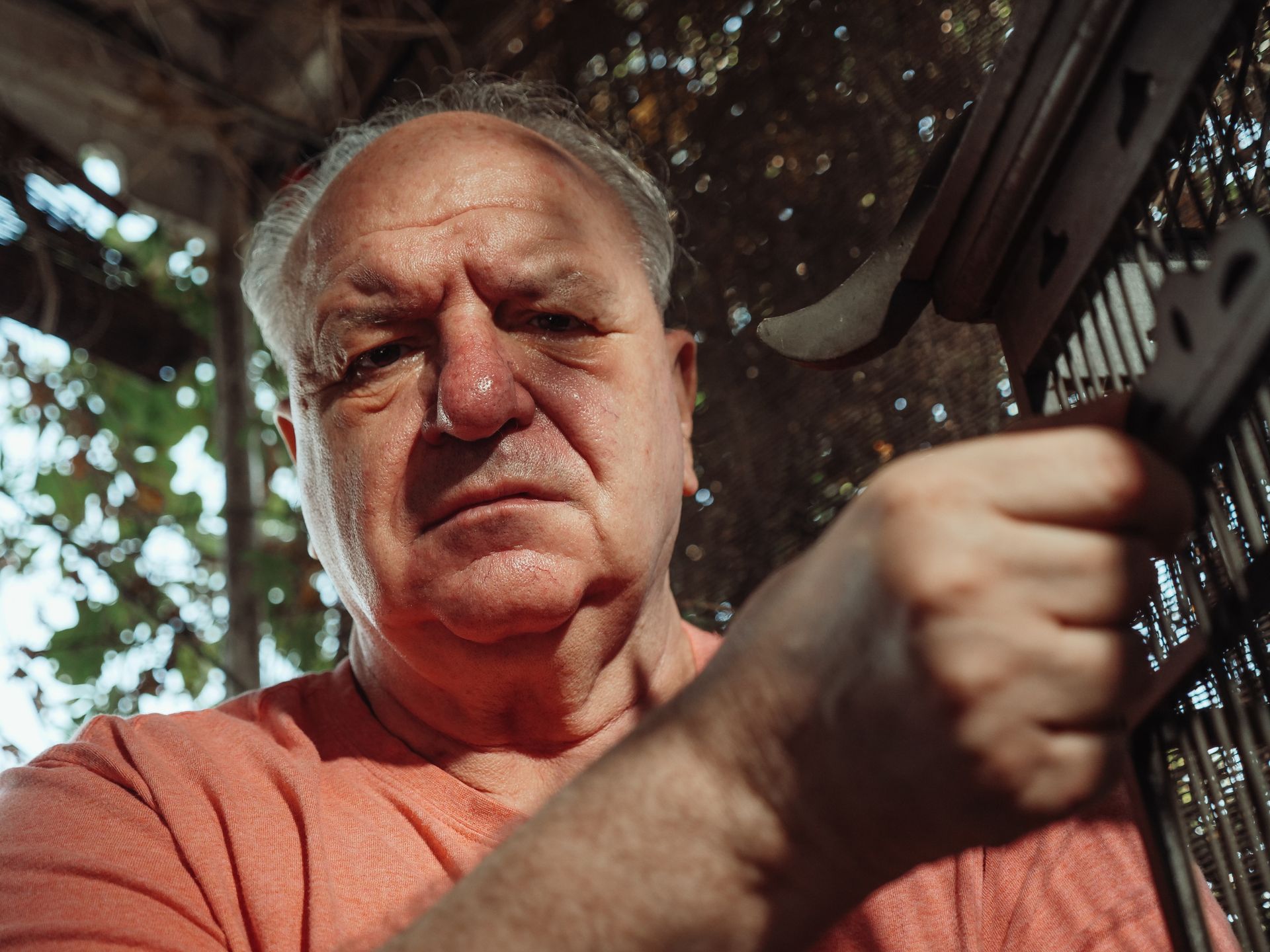 An Elderly Man Crying while Holding a Cage