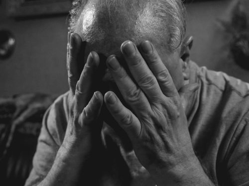 Free Elderly man covering face with hands, evoking emotions of sadness and stress. Stock Photo