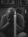 A Grayscale of a Man with His Hands on His Face