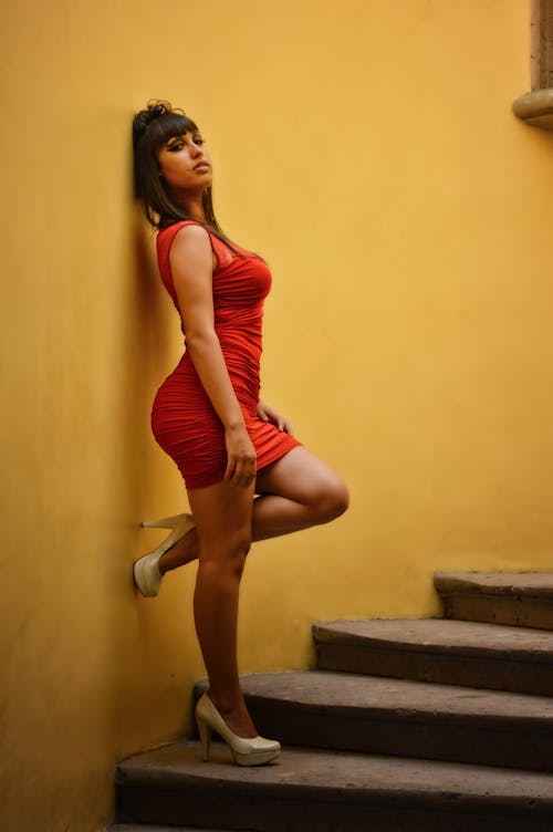 Selective Focus Photography of Woman Wearing Red Tank Ruched Mini Dress Leaning on Stairs Wall