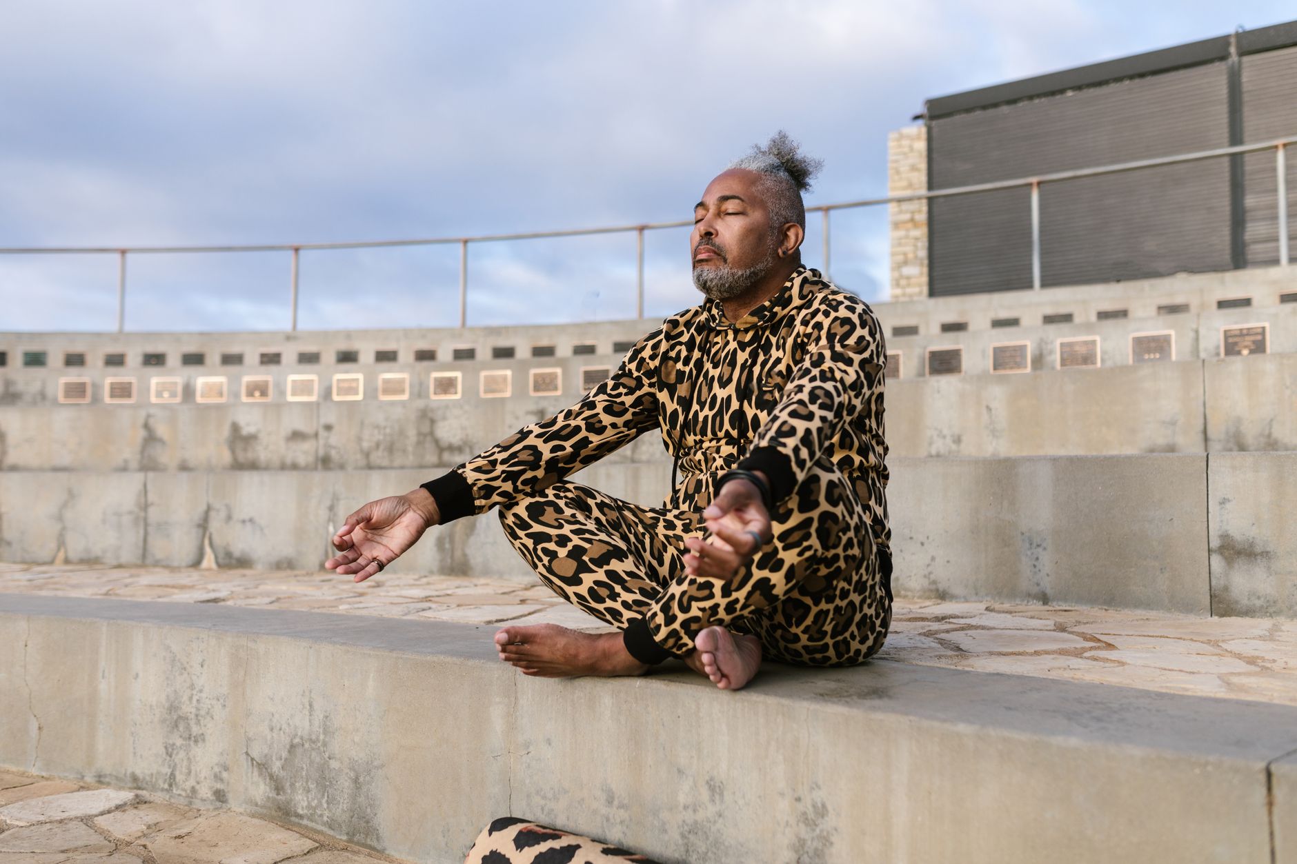 每天10分鐘冥想教學:如何簡單實踐與獲益 Man in leopard print attire meditating outdoors, eyes closed, promoting wellness.