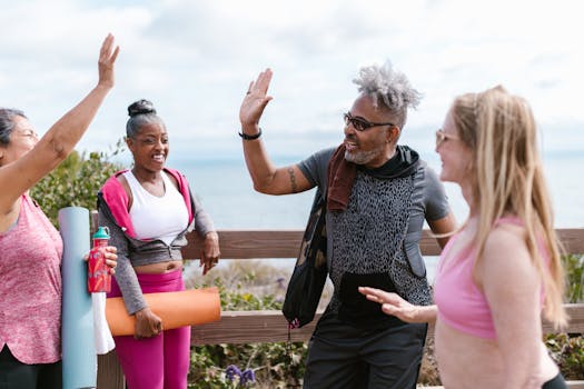 Group of senior adults sharing a joyful outdoor yoga session near the sea.