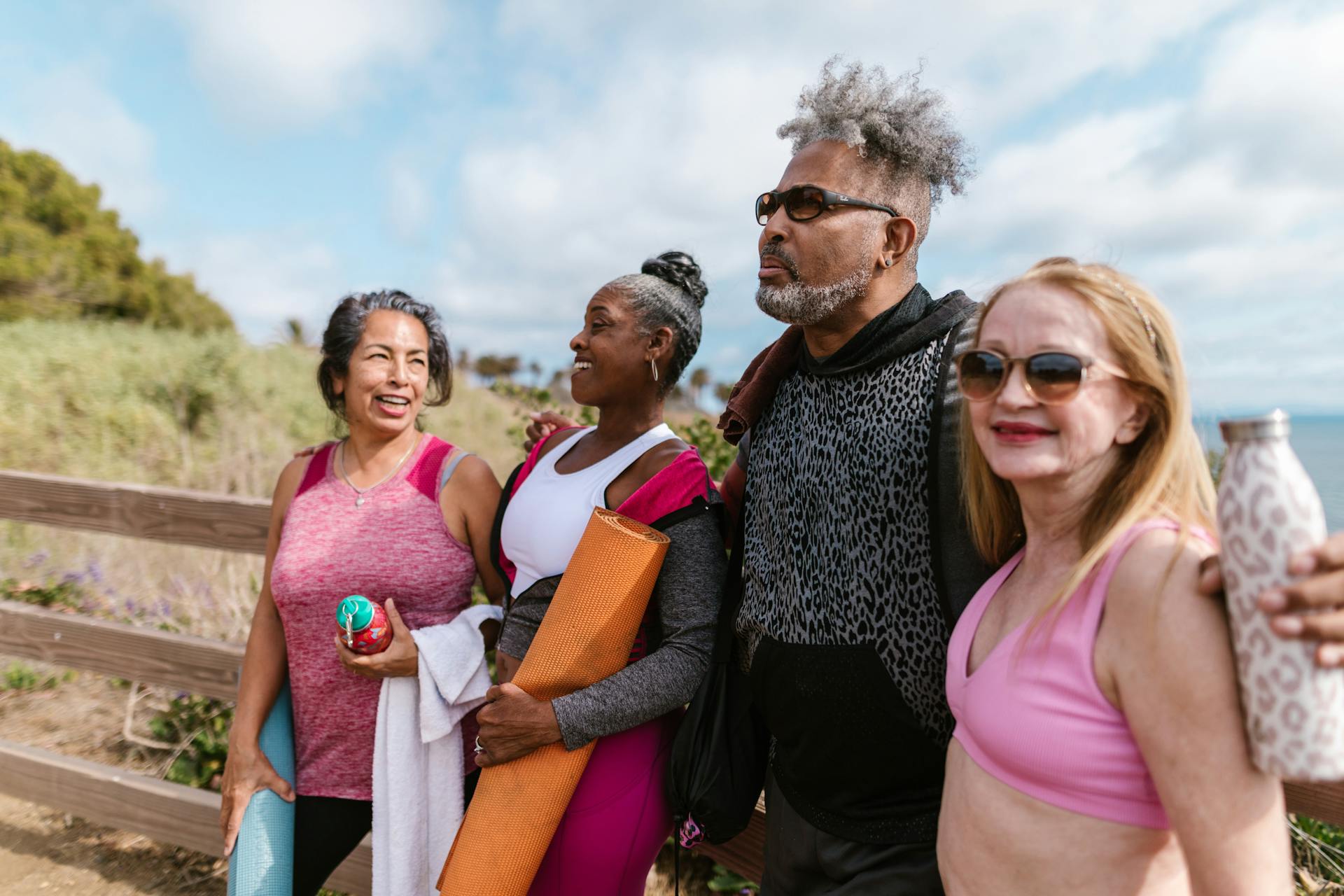 Happy seniors gather outdoors for a group yoga session, embracing friendship and wellness.