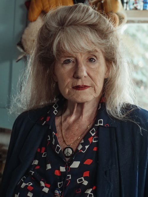 An Elderly Woman in Blue Shirt Looking with a Serious Face
