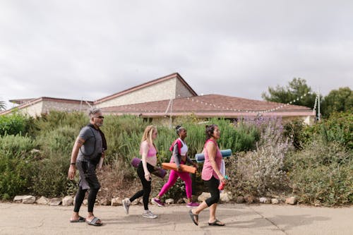 People with Yoga Mats Walking Together