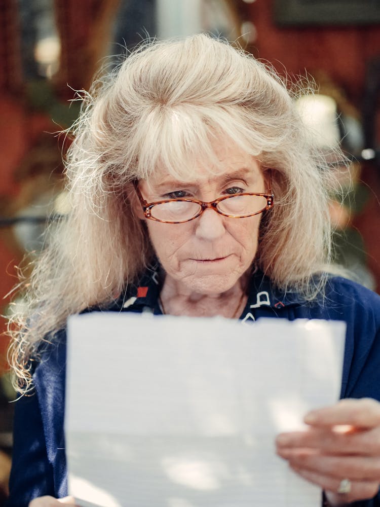 An Elderly Woman Reading A Letter