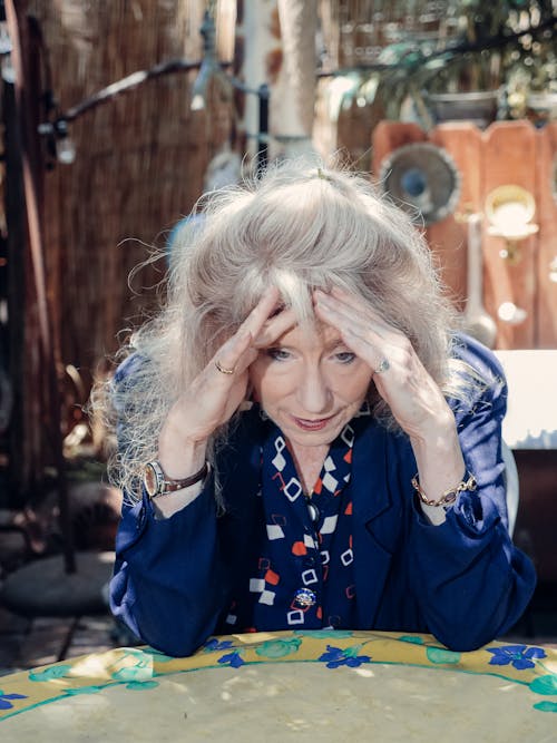 Elderly Woman in Blue Blazer Sitting at Table