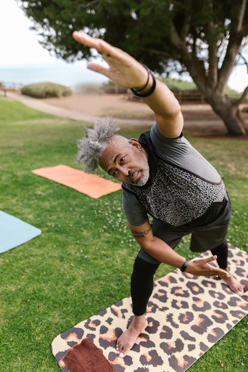 Man Standing on a Mat Doing Yoga