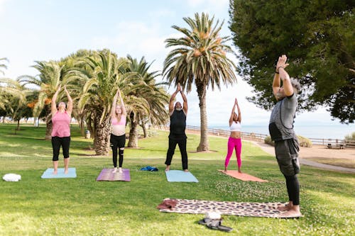 Free An Elderly People Standing while Meditating at the Park Stock Photo