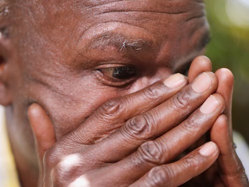 Close-Up Shot of a Lonely Man Covering His Face with His Hands