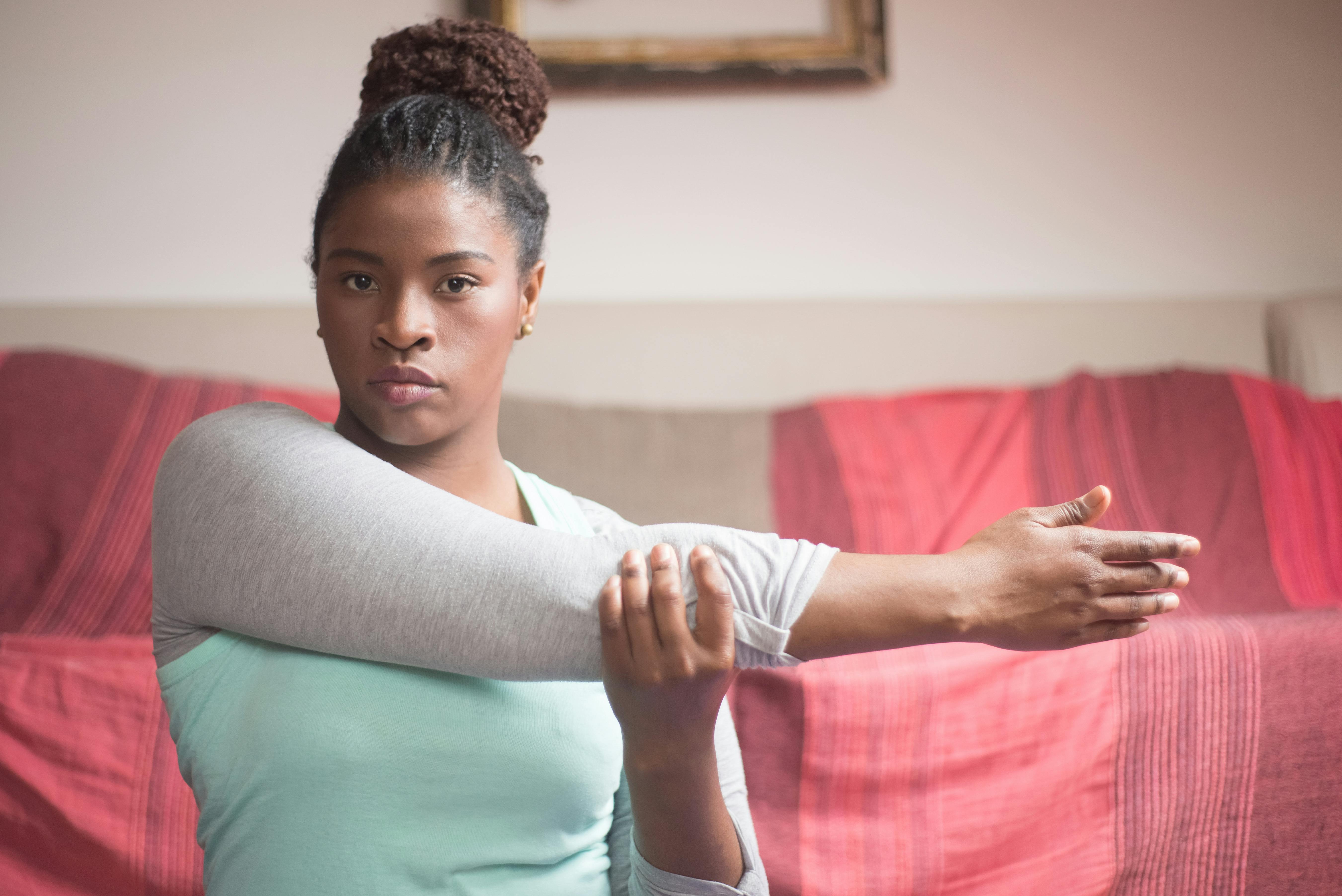 Black woman doing arm workout with resistance band at fitness gym