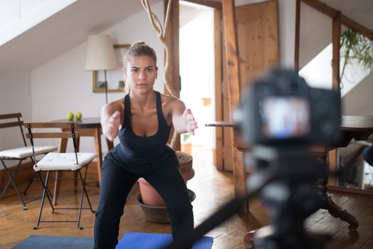Woman practicing yoga indoors with a camera setup in Portugal, promoting a healthy lifestyle.