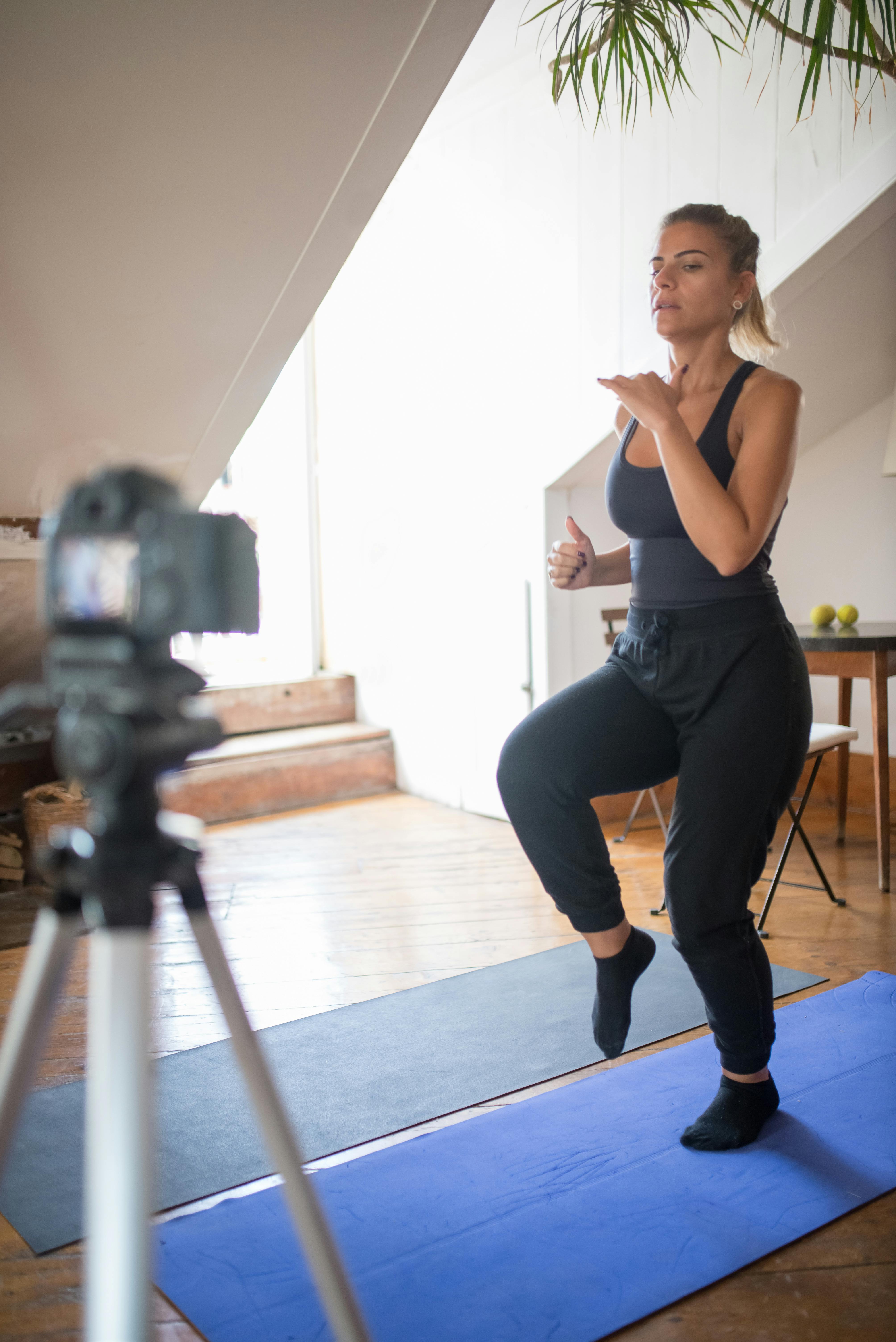 woman in tank top and black leggings doing exercise