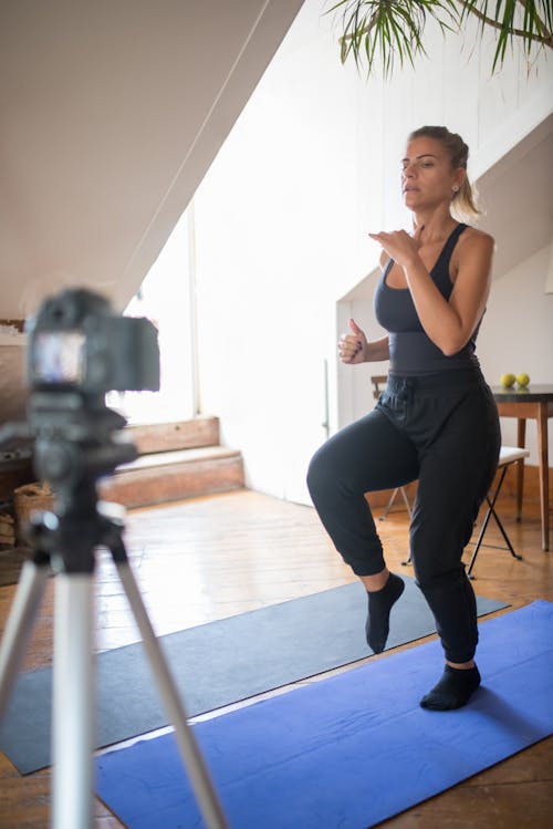 Woman in Tank Top and Black Leggings Doing Exercise