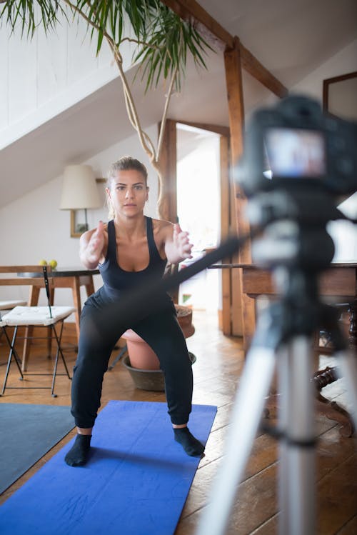 A Woman Doing Squats while Facing the Camera