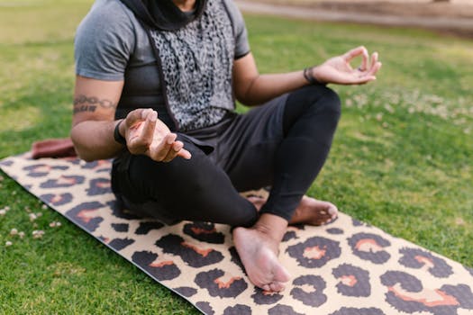 Man meditating in lotus pose on a leopard print yoga mat outdoors, enhancing mindfulness.