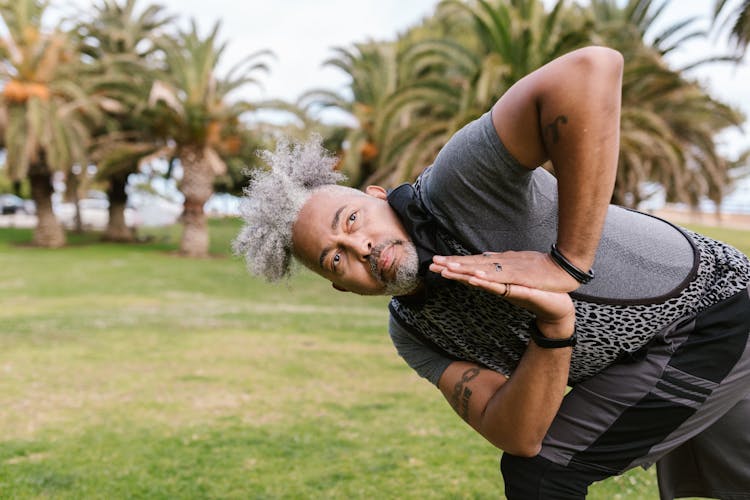 Man Training Yoga In Park