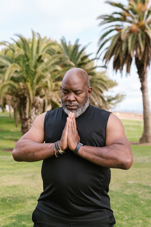 An Elderly Man in Black Tank Top Meditating with His Eyes Closed