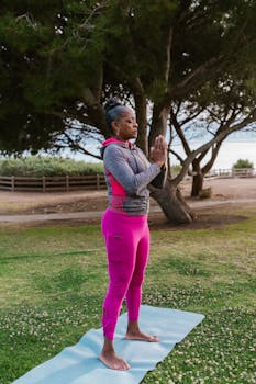 Adult woman practicing yoga poses outdoors in a serene park setting.