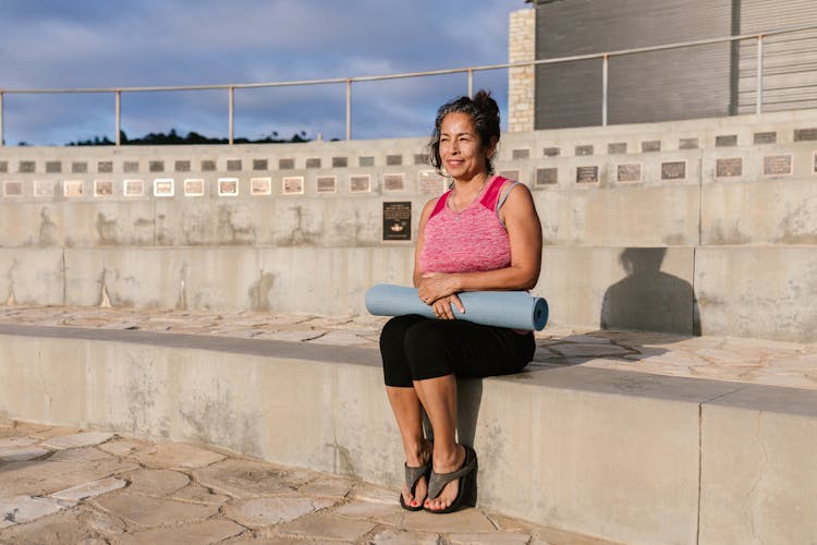 Woman Sitting On A Concrete Platform Resting