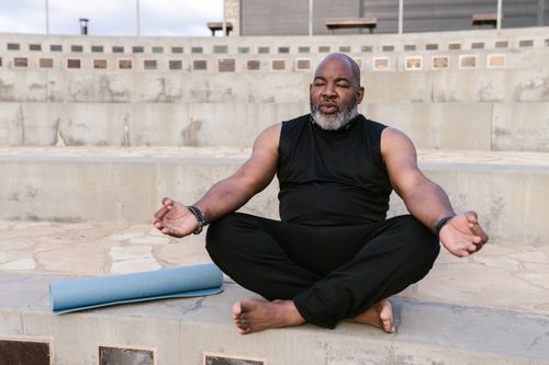 Free Senior man meditating outdoors promoting tranquility and wellness through yoga practice. Stock Photo