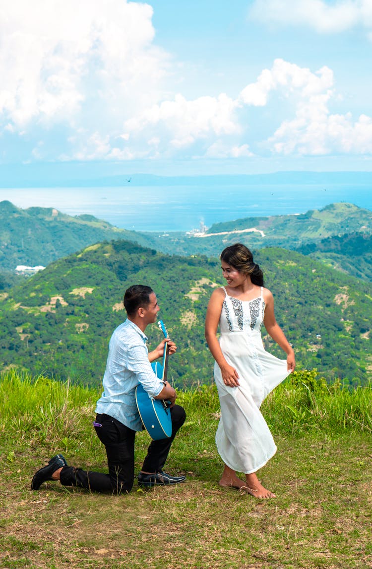 Man Kneeling While Serenading His Woman