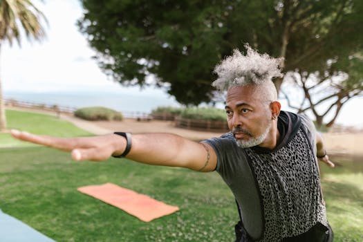 Adult man practicing yoga in a sunny park, focusing on balance and exercise.