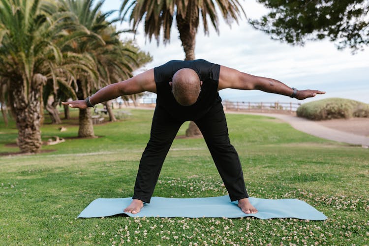 Man Training Yoga In Park