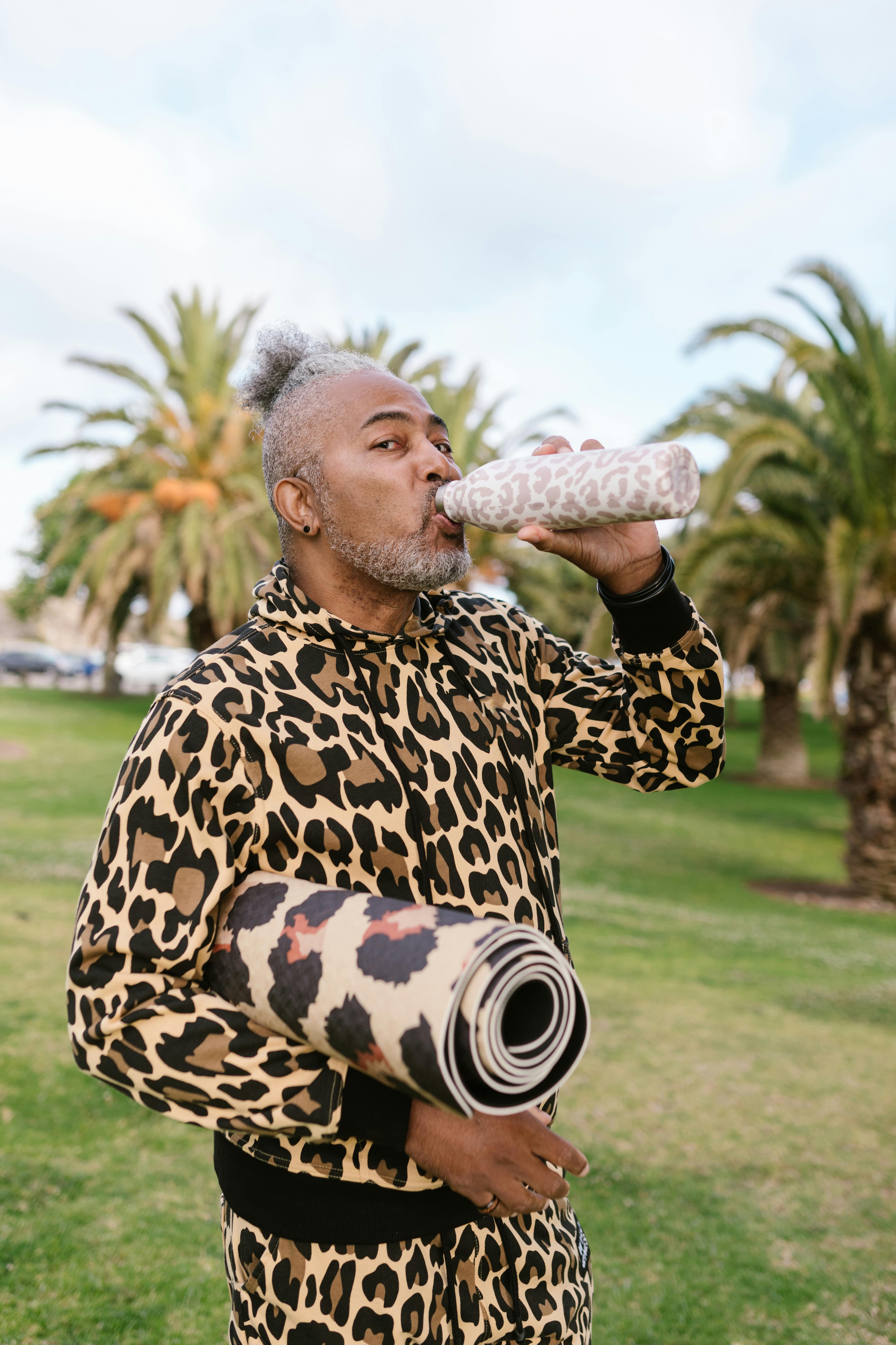 Man Drinking While Holding His Rolled Yoga Mat · Free Stock Photo