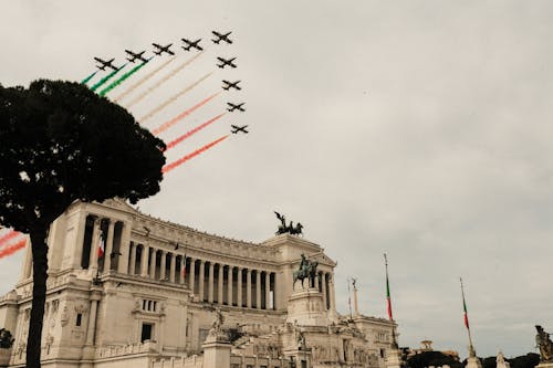Free Low angle of air show over Victor Emmanuel Monument with sculptures and colonnade during National Unity and Armed Forces Day in Italy Stock Photo