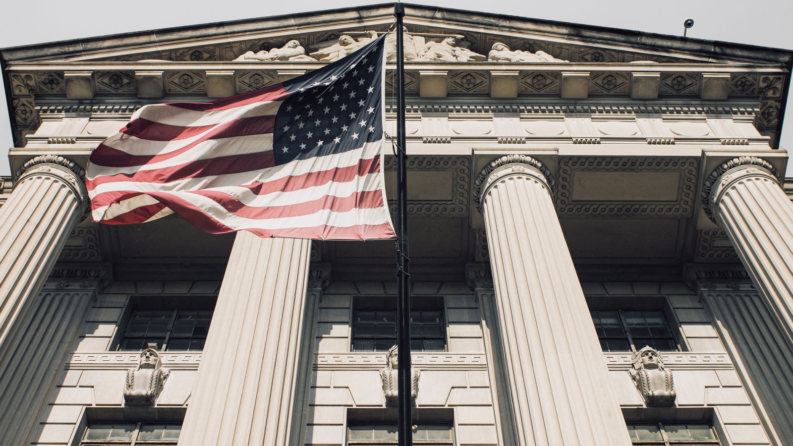 Majestic view of a government building with the American flag waving proudly.
