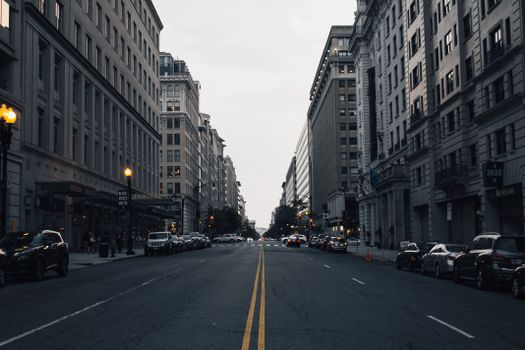 A serene cityscape showcasing an empty street lined with tall, classic architecture buildings.