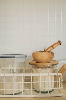 Organized kitchen setup with stored flour and a wooden mortar and pestle.