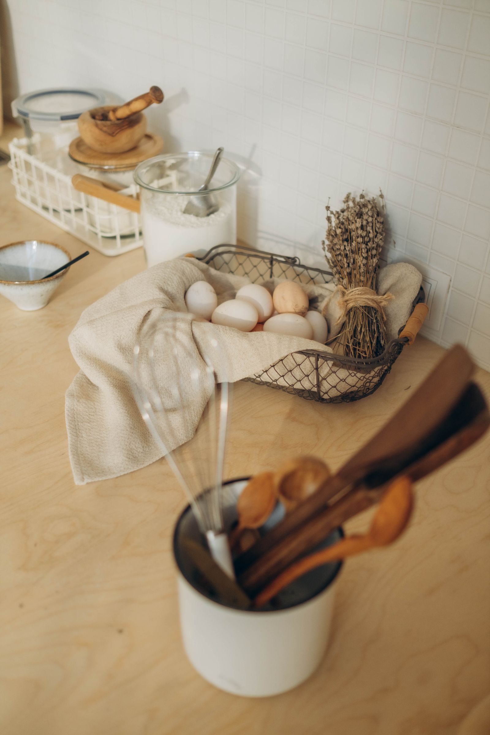 Eggs in a wire basket on a kitchen counter with linen