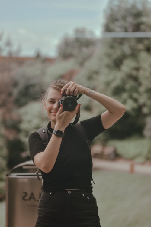 Woman in Black Shirt Taking Photos
