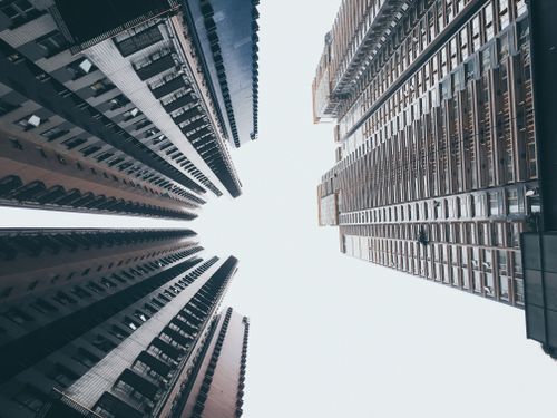 Free A striking low-angle perspective of Hong Kong skyscrapers reaching toward a bright sky. Stock Photo