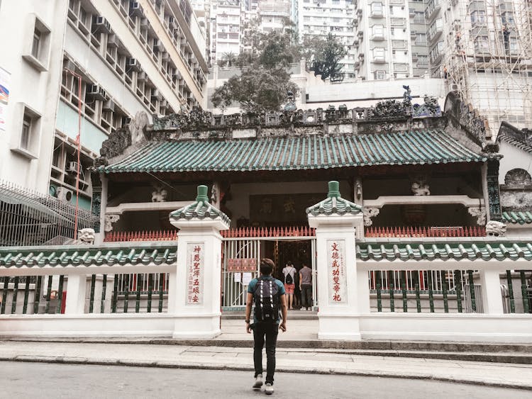 
A Man Carrying A Backpack Looking At The Man Mo Temple In Hong Kong