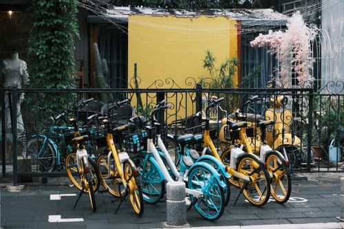 Free Bicycles parked along a vibrant street in Xiamen, Fujian, China, with a colorful backdrop. Stock Photo