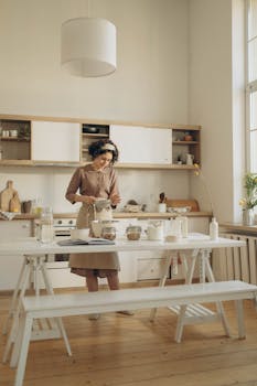 Woman in brown dress baking in a cozy, modern kitchen setting.