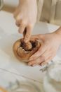 Person Holding Brown Wooden Round Ornament