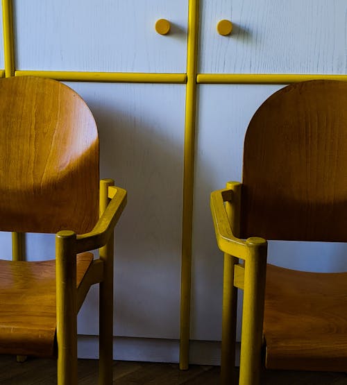 Chairs placed near white cupboard