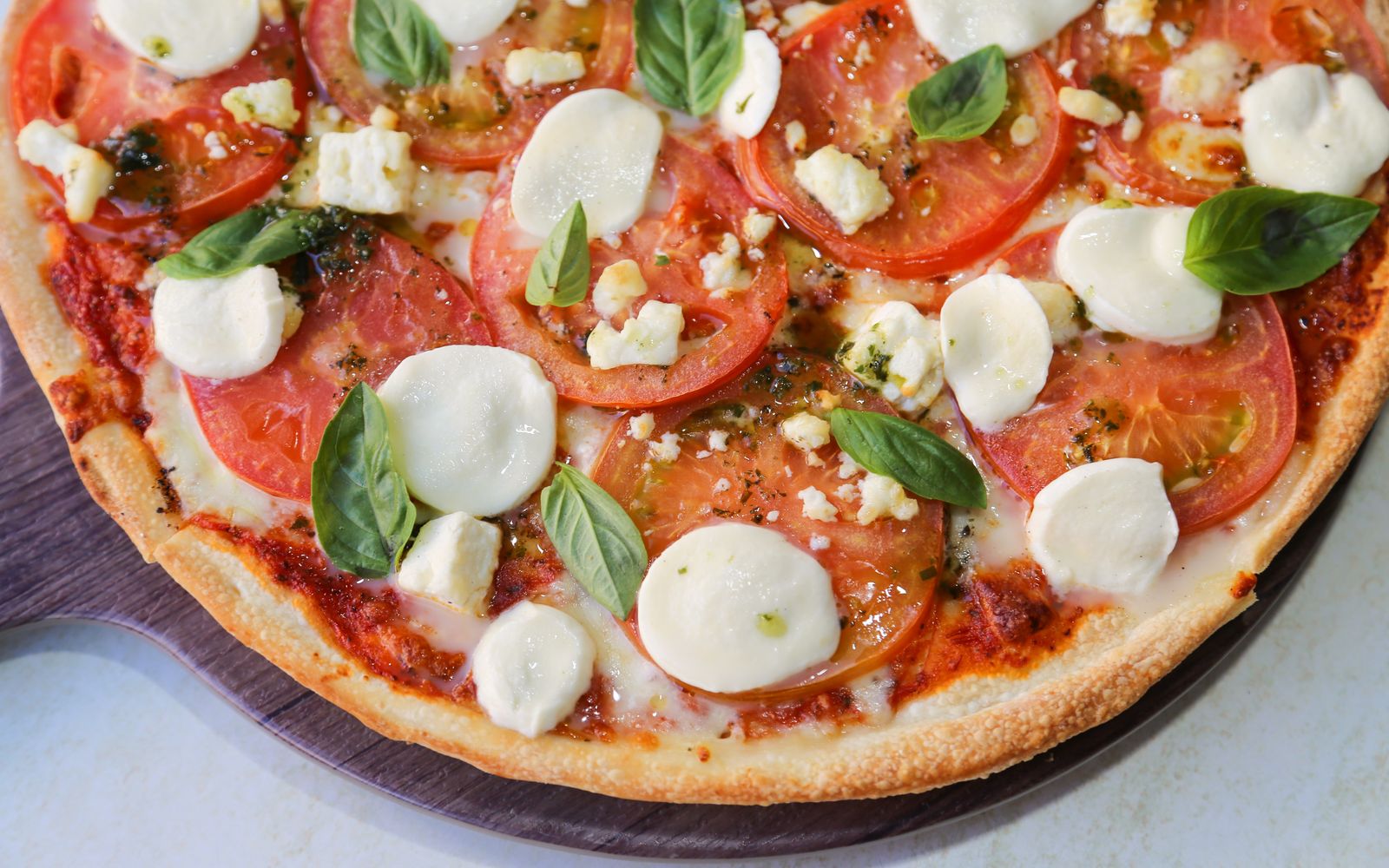 Foto de Pizza de frigideira de muçarela e tomate com salada verde