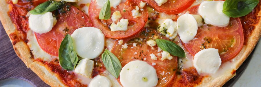 Foto de Pizza de frigideira de muçarela e tomate com salada verde