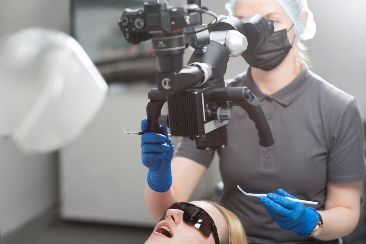 A dentist working through a microscope