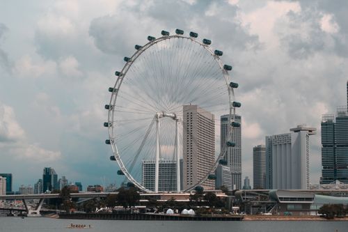 Free The iconic Singapore Flyer with city skyline on a cloudy day, showcasing urban architecture. Stock Photo