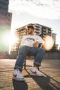 Man in White Crew Neck T-shirt and Blue Denim Jeans Sitting on Brown Wooden Bench