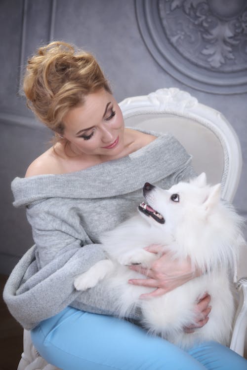 Бесплатное стоковое фото с белая собака, вертикальный выстрел, женщина