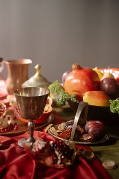 A still life depicting a variety of fruits and a goblet in a Renaissance style setting.
